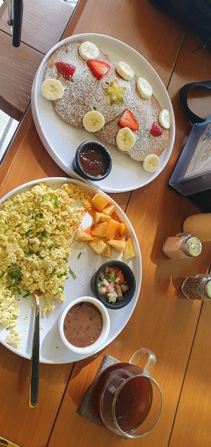 Tofu scramble with potatos, pico de gallo and beans and pancakes with fruit. at Herbivoro in Cancun