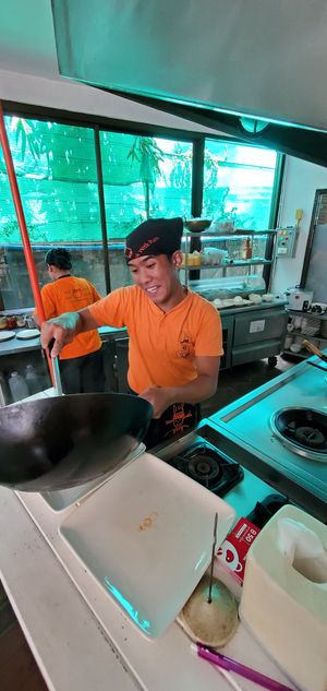 Friendly chef preparing meal in front of us at Pum Thai Restaurant & Cooking School in Phuket