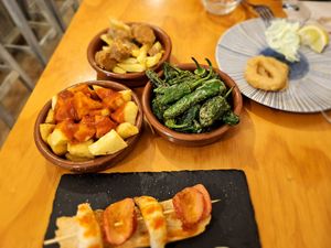 Patatas bravas, pimientos de Padrón and chorizo en vino. at La Vegana Taperia in Malaga
