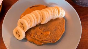 Vegan, gf pancakes topped with banana and peanut butter at O Diplomata in Porto