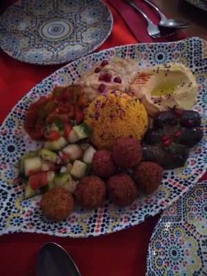 8er Mezze vegan, Gemüseratatouille, Baba Ganoush, Hummus, Weinblätter mit Reis gefüllt, Falafel, marrokanischer Salat und Taboulé in der Mitte, dazu Fladenbrot und Olivenbrot at Barbès Bar in Luzern