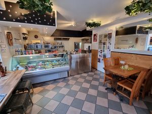 Interior, there are 2 tables with each 4 chairs on the side at De Vegetarische Toko in The Hague