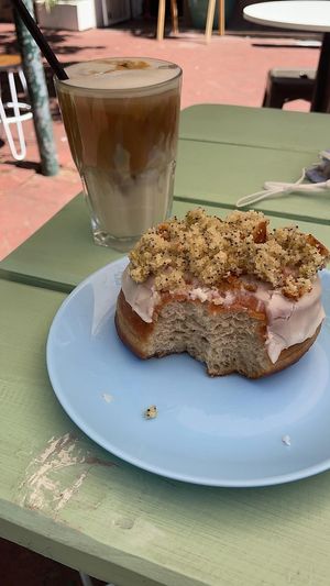 Lemon drizzle poppyseed donut and an oat milk iced coffee  at Grumpy & Runt in Western Cape