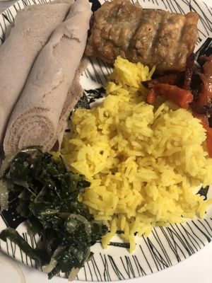Injera rolls on the left, lentil sambusa on top, rice and different parts of the vegan sampler.  at Ras Plant Based in Brooklyn