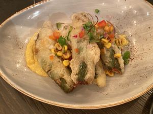 Crisp zucchini flowers filled with queso, bechamel, and jalapeño, charred corn purée, salsa roja, and hot "honey”  at Vandal in Newtown