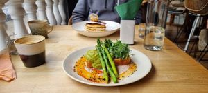 Avocado and asparagus brunch with pancakes in the background. at Shrub in Chester