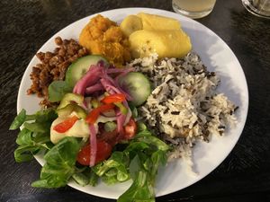 Yemaya’s box with rice mix (a bit dry), cooked banana, gruntu (here: pumpkin), spicy tempeh (barely spicy) and salad at Yemaya's Vegan Corner in Amsterdam