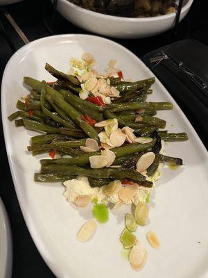 ROASTED GREEN BEANS $16.00 Oven roasted garlic & chilli green beans served in a bed of feta, roasted almonds. (We paid for this extra on top of banquet)   at Nonna's Nightmare in West End