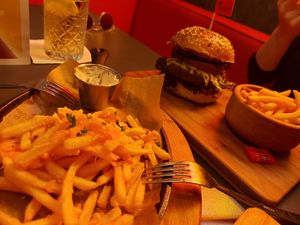 Fries with cheddar cheese, pear burger in the back at The Street  in Prague