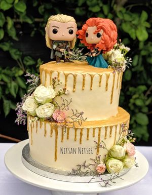 Gold drip cake decorated with fresh flowers. at Alice in Cakeland in Rotterdam