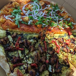 Half vegan artichoke pesto pizza and half Buffalo cauliflower pizza (all vegan with house made cashew ricotta).  at Flatbread & Butter in St Petersburg