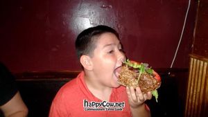My son trying to navigate the HUGE Philly cheese-fake (vegan version) at Liquid Earth in Baltimore