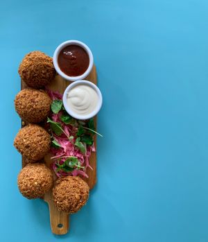 Falafel: Freshly fried chickpea and fava croquettes served with Tarator (tahini and lemon juice) and pickled cabbage.  at Muito BEY in Lisbon
