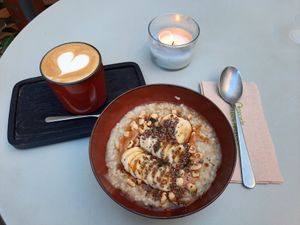 Havermout met banaan, pindakaas en noten met een flat white at Oats Day Long in Ghent