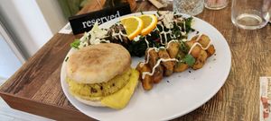 A savory plate, with a muffin, tofu steak and vegan cheese accompanied by kale salad at Maison Sukoon in Paris