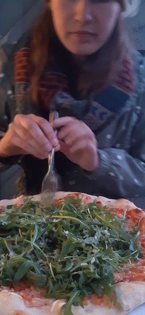 Leckere Pizza und hungrige Freundin im Hintergrund at Mama Earth in Salzburg