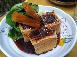 Fried tofu filled with savoury mushrooms, on a sweet soy sauce and steamed Pak choi at Ong Tao Vegan in Frankfurt