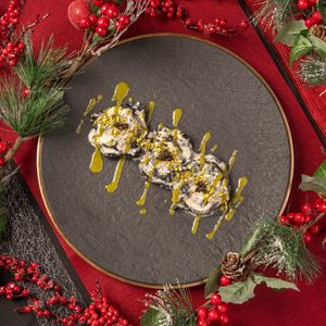 Deleita tu paladar con ravioli de masa negra rellenos de ragout de setas, abrazados por una sedosa salsa de trufa, pesto de pistacho, crujientes pistachos triturados y el toque mag at Choose in Madrid