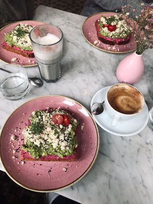 Avo-Breads with "veta", flat white & black sesame latte  at OM NOM NOM CAFÉ in Munich