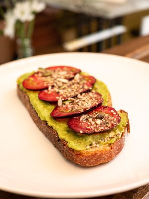 Tostada de aguacate con tomate y semillas at Üla Café in Barcelona