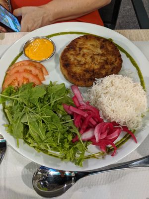 Veggie burger on a plate with rice and salad at Veggie Garden in Sitges