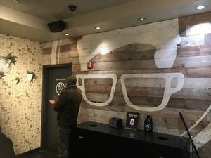 Inside, with an available bathroom; the glasses on the wall are the company logo.  at Gregory's Coffee - 44th St in New York City