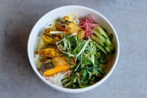Cha Ca La Vong - Turmeric Fish - “Fish” tofu, turmeric, galangal, dill, pickles, cucumber, rice noodles, crispy shallots, peanuts, nuoc cham at Chi in Vancouver