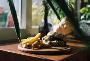 Beyond Meat Burger (vegan) with onion compote, vegan truffle mayonaise, rucola, vegan burger roll and fresh farmer's-fries! at New-West Comfort Food in Amsterdam