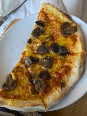 Half of a mushroom vegan truffle pizza with garlic at The Dead Pigeon in Rochester