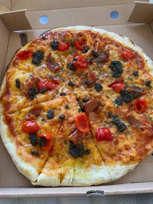 Vegan pizza with black olive tapenade spicy red peppers and sun ripened tomatoes. Delicious! at The Dead Pigeon in Rochester