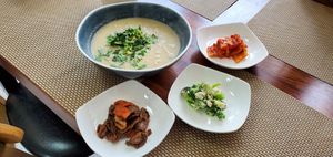 Perilla seed soup (with noodles), along with some of the side dishes served with the meal at Soban Vegan 소반 비건식당 in Busan