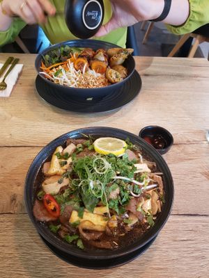 Vorne: Pho mit Nudeln, Gemüse Sojabällchen,Austernpilzen, Seitan und Tofu, hinten gebratene Nudeln mit BBQ-Spießen at Vevi in Vienna