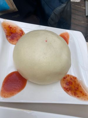 steamed Vietnamese bao bun filled with soy, glass noodles, morels, carrots, peas, sweet chili sauce, chili sauce at Vevi in Vienna