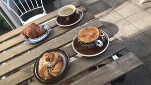 A delightful breakfast spot! Spiced latte and Americano with cinnamon swirl bun and croissant in the sunny courtyard!   at Loaf Sourdough Bakery in Utrecht