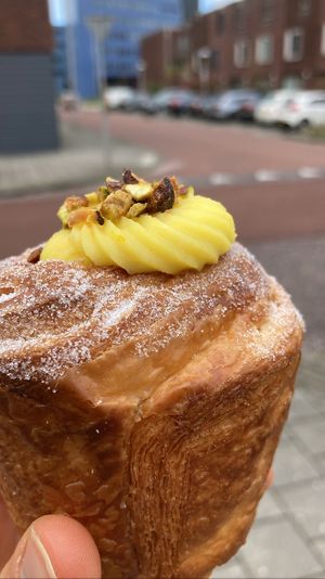 Cruffin filled with orange cream and topped with pistachio   at Loaf Sourdough Bakery in Utrecht