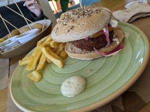 Hamburguesa vegetariana (vegana) de arroz y lenteja,  cebolla morada, lechuga, tomate, ajos rostizados y crema de champiñones at Agüita in Salinas