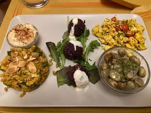 Combine dish with hummus, spelt with carrot sauce, courgettes and almonds, violet cabbage balls with vegan yoghurt sauce, scrambled tofu, broad beans with wild fennel and seitan at Laboratorio - Food. Drink. Green Cosmetics in Jesi