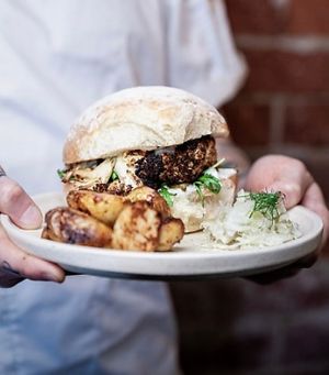 Crispy oven-roasted cauliflower steak burger with dill ‘cream cheese’, rocket, pickled chilli and
‘aioli’ with a side of sauerkraut and roasted potatoes at Mother in Fremantle