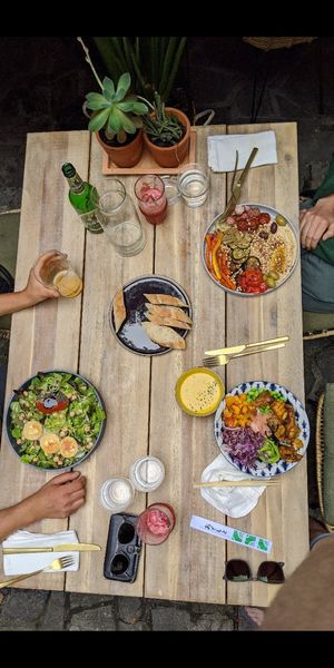 Hummus + grilled veggies (vegan) at top, salat with goat cheese (veggie) on the left, right corner "bowl" dish. 2 delicious juices and slow. beer at Gostilna Vida in Ljubljana