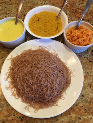 String Hoppers (steamed red rice noodles). Served with Coconut Milk Curry (left), Dhal Curry (middle) & Coconut Sambol (right). It's like a stack of tortillas that you load, roll & eat. at House of Curry in Rosemount