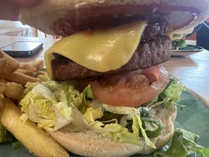 Burger and chips, moving mountainous burger and we paid extra for some ‘bacon’ which was tempeh. Not sure what cheese they used but it was great tasted likeAmerican cheese slic at Thrive in Cambridge