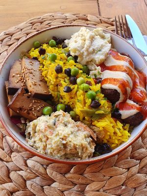 Bowl with smoked tofu, falafels, tasty rice, 2 sauces (zuchini and eggplants) and salad underneath. AMAZING !!!! at Pisekar Vegan Food in Antalya