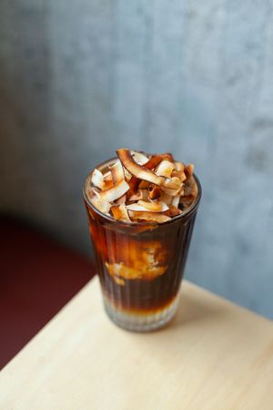 Iced coconut long black. Made with fresh coconut water, coconut flesh, topped with fresh organic espresso and garnished with homemade toasted coconut flakes. at Pimp My Salad in Bangkok