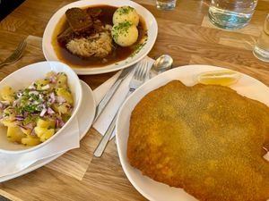 Kümmelbraten, potato salad, and schnitzel at Velani in Vienna