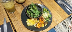 plate of vegetables with potato gratin and a bowl of dehydrated kale at Naya Studio in Paris