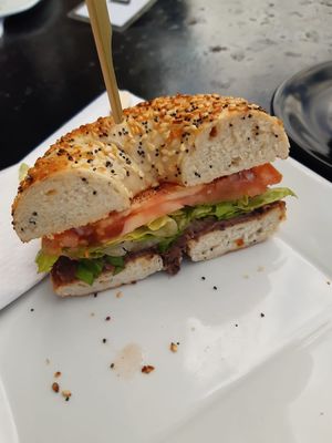 Bagel com pasta picante de feijão preto e salada. at Cortado Tasting Room in Bedford