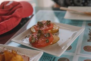 Mordeduras de papas con tomates y alcaparras. at Manumaga in Mojacar