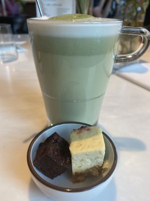 Matcha latte with complementary sweets, cheesecake and brownie. at The Green Room - Cityhotel Wood in Middelburg