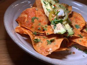 Chilaquiles Rojos: Corn Chips tossed in a mild Tomato Salsa, topped with Avocado, Radish, Pickled Jalapeños.  From Vegan Taco Tuesday 1/16/24 at 600 Kitchen and Bar in Kalamazoo