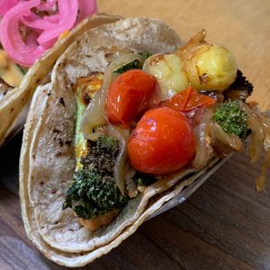 Charred Broccoli Taco: Sun-Dried Tomato Hummus, Caramelized Pearl Onions, Blistered Tomatoes.  From Vegan Taco Tuesday 7/9/24 (every 2nd Tuesday of the month) at 600 Kitchen and Bar in Kalamazoo